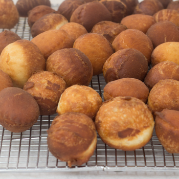 Beignets cooling on a rack.