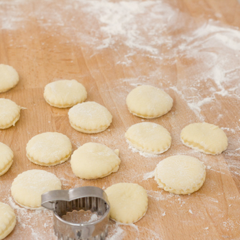 Cutting the beignets out of dough with a pastry cutter.